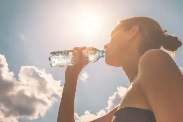 Hydration: The Secret Ingredient for a Toned Stomach and Enhanced Fitness 3 Image of woman drinking water to hydrate Wivenhoe after run.